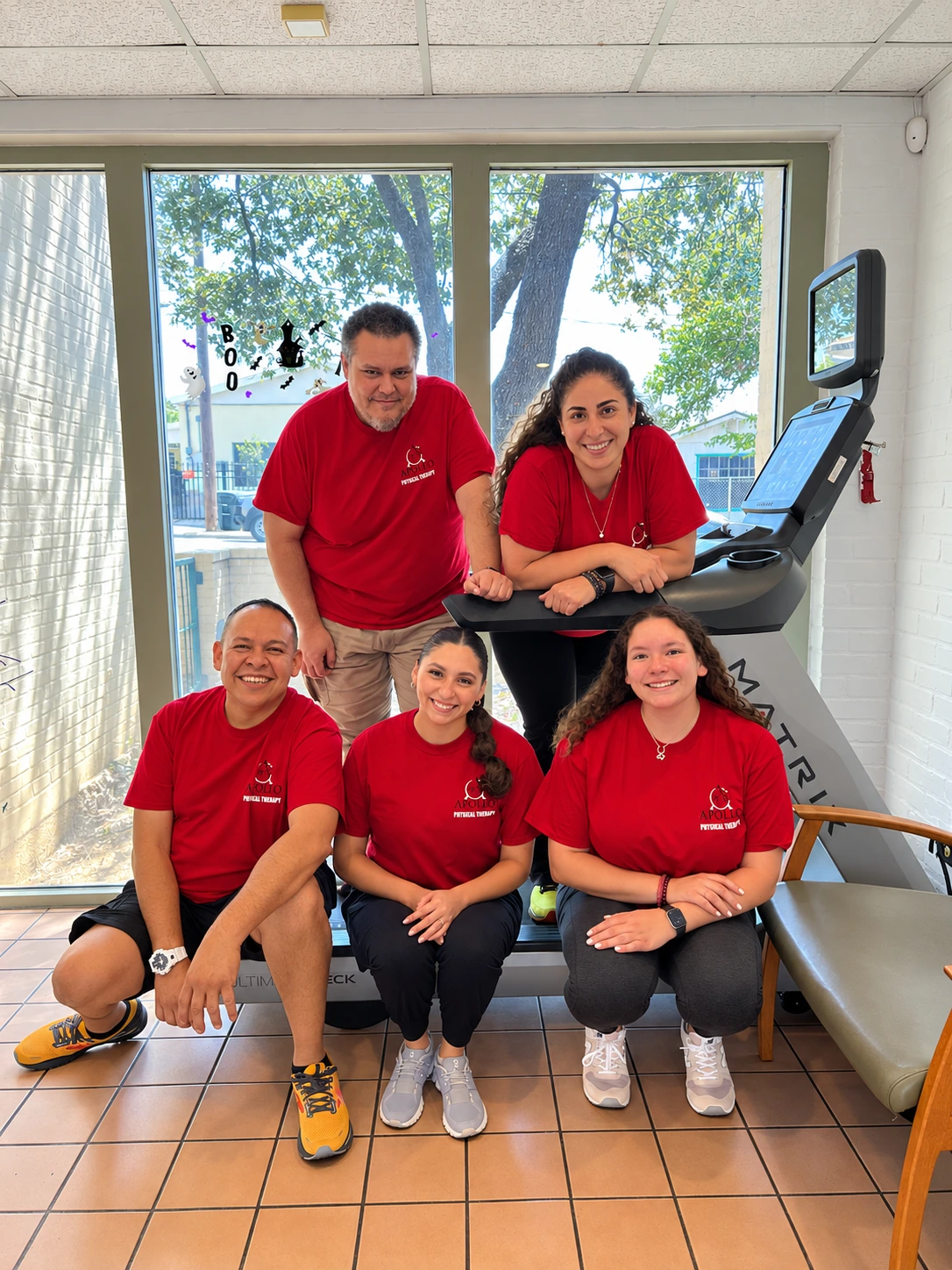 Apollo team together in their red physical therapy shirts